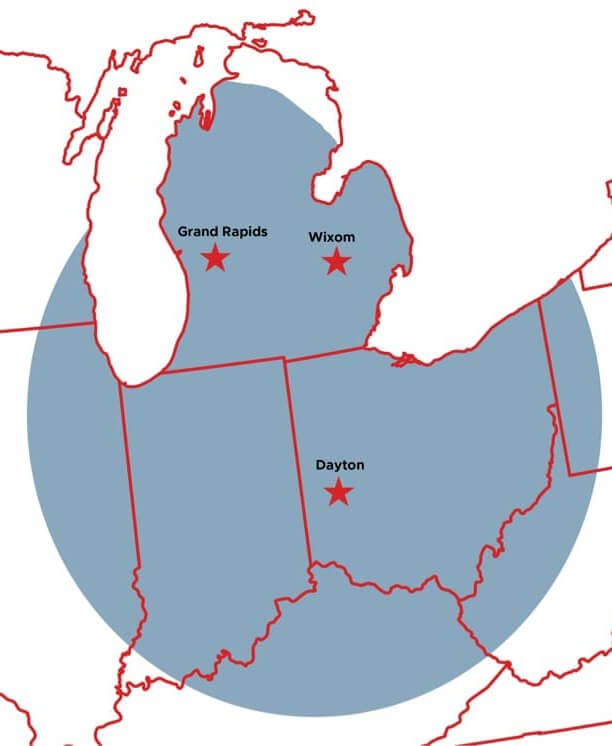 A close-up map showing a section of the United States. The states are white and the outlines are red. A blue circle shows the PM Technologies service area, covering parts of Michigan, Illinois, Indiana, Ohio, Pennsylvania, and Kentucky. Red stars designate the cities of Grand Rapids, MI; WIxom, MI; and Dayton, OH.