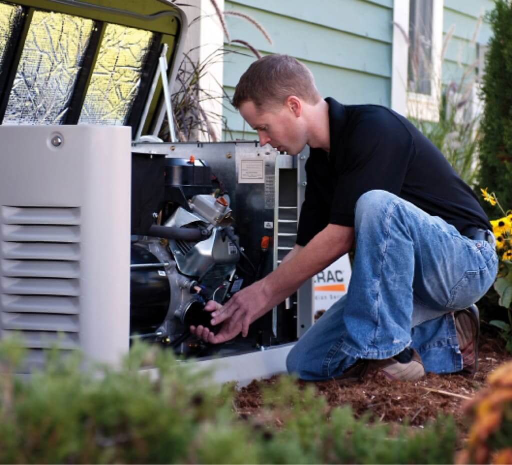 A technician kneeling and working on an open Generac generator outside of a home.