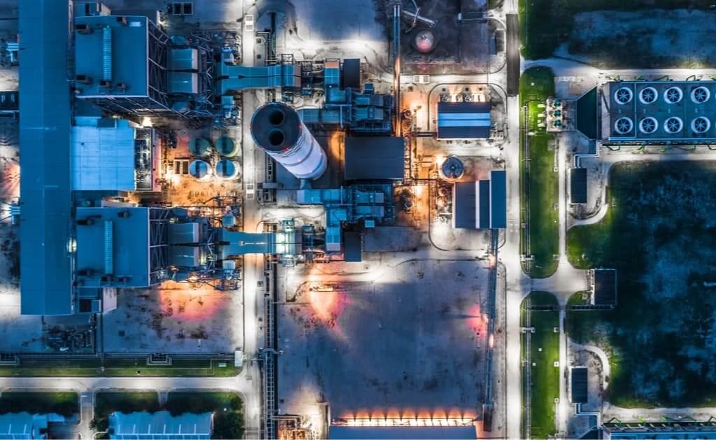 An overhead shot of an industrial area with all of the exterior lights around the area lit up.